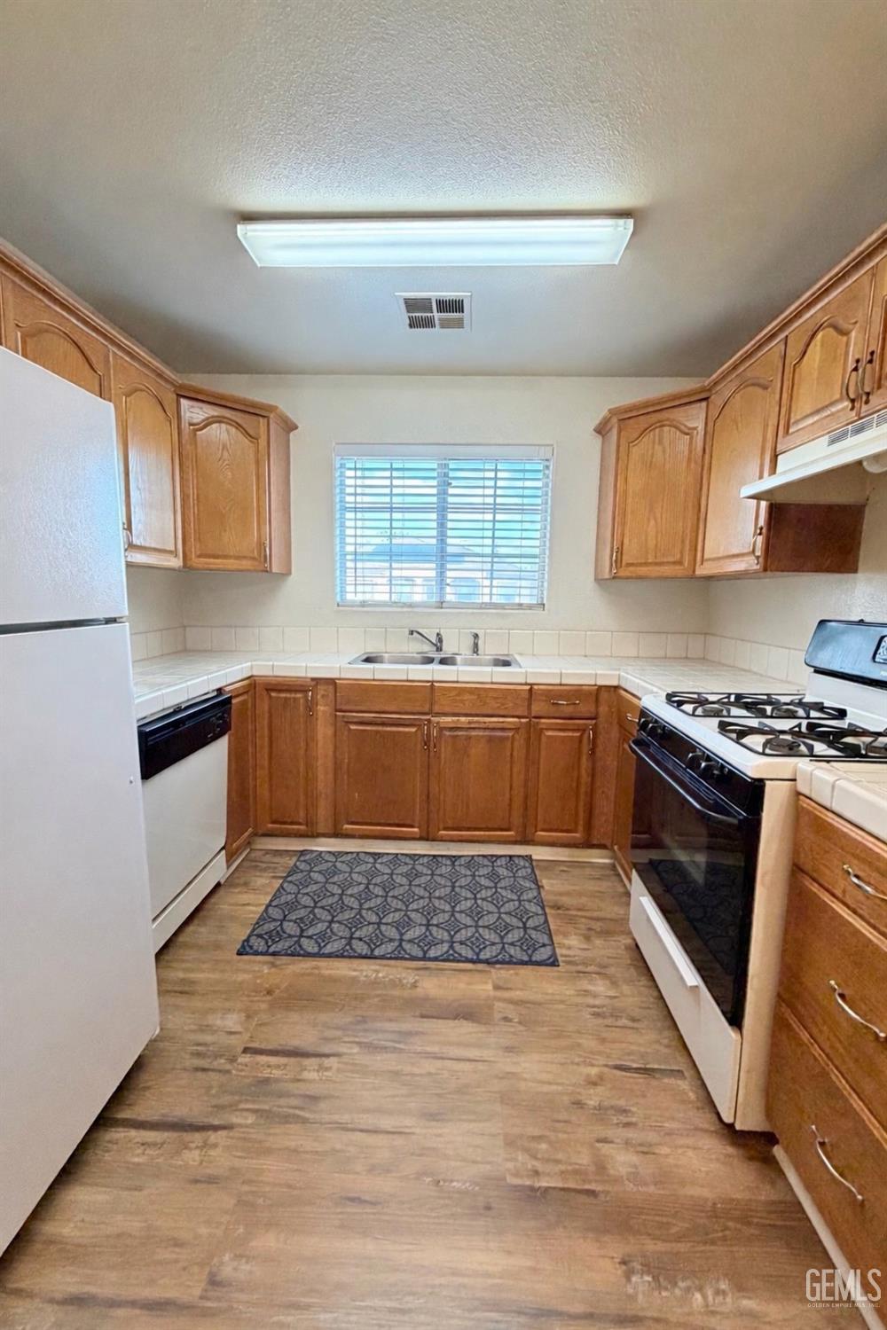 Undisclosed Address Bakersfield, CA 93313 - Photo 5 of 18 a kitchen with a sink a stove and cabinets