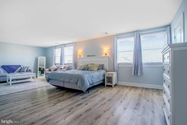 a spacious bedroom with a bed a couch and a window