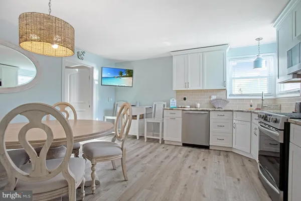 a kitchen with dining table and stainless steel appliances