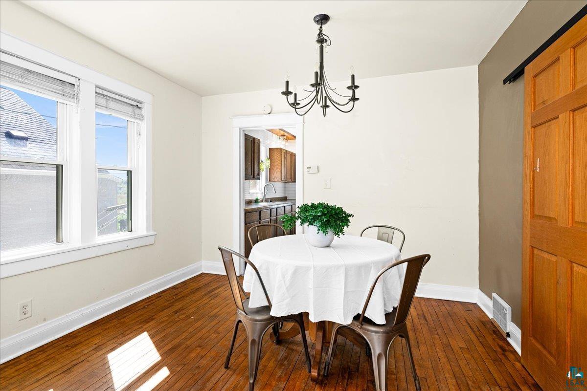 519 3rd Avenue Proctor, MN 55810 - Photo 9 of 25 Dining room with dark wood-type flooring, a chandelier, and sink