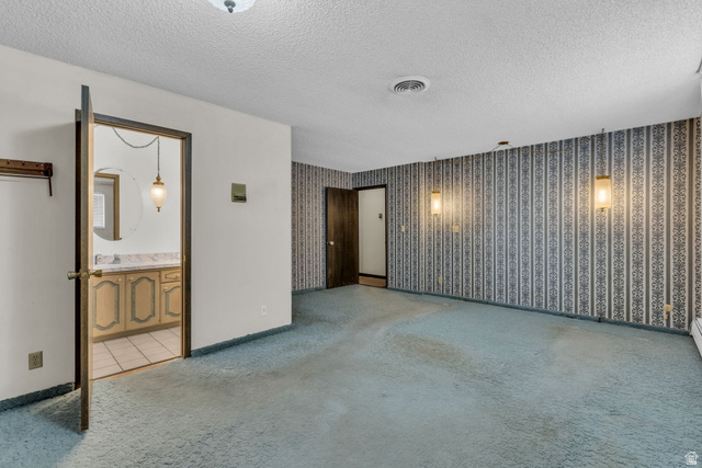 10705 Green Ridge Drive Sandy, UT 84070 - Photo 16 of 55 Empty room featuring light colored carpet, a textured ceiling, and wallpapered walls