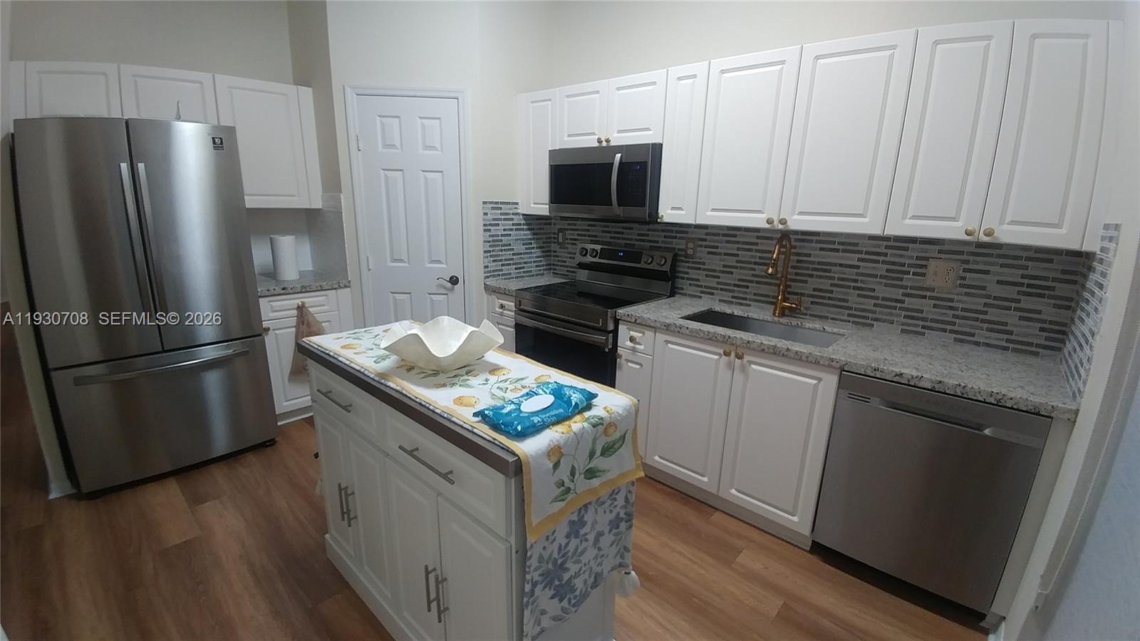 2452 Southeast 19th Court Homestead, FL 33035 - Photo 4 of 10 a kitchen with stainless steel appliances granite countertop a refrigerator stove and microwave