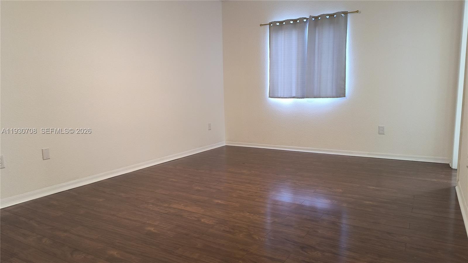 2452 Southeast 19th Court Homestead, FL 33035 - Photo 6 of 10 an empty room with wooden floor and windows