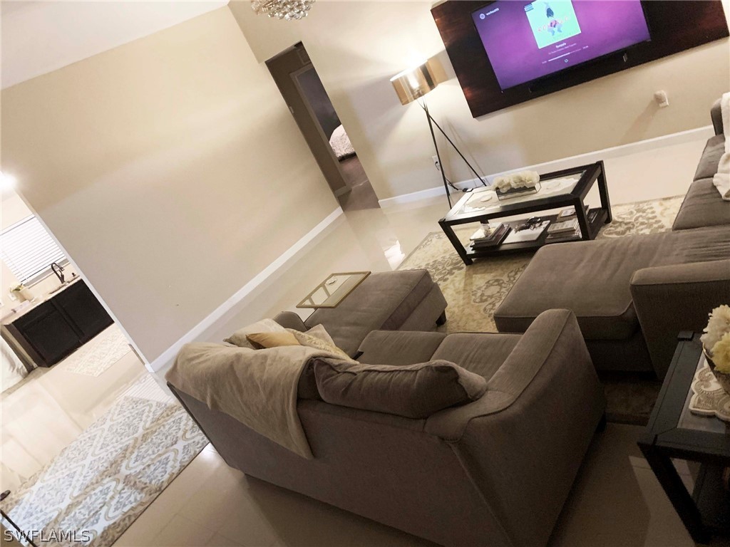 8382 Trillium Road Fort Myers, FL 33967 - Photo 2 of 19 a living room with furniture and a flat screen tv