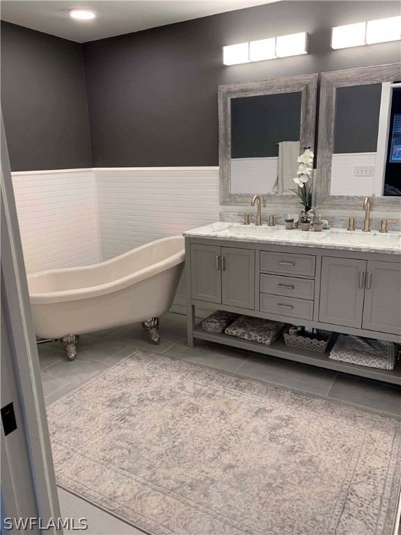 8382 Trillium Road Fort Myers, FL 33967 - Photo 6 of 19 a bathroom with a granite countertop sink a mirror and a bathtub
