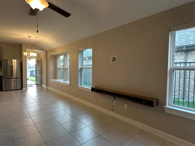 a view of a kitchen with kitchen island granite countertop a large counter top space appliances and a ceiling fan