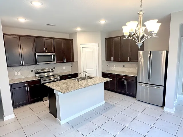 a large kitchen with a stove a sink and a refrigerator