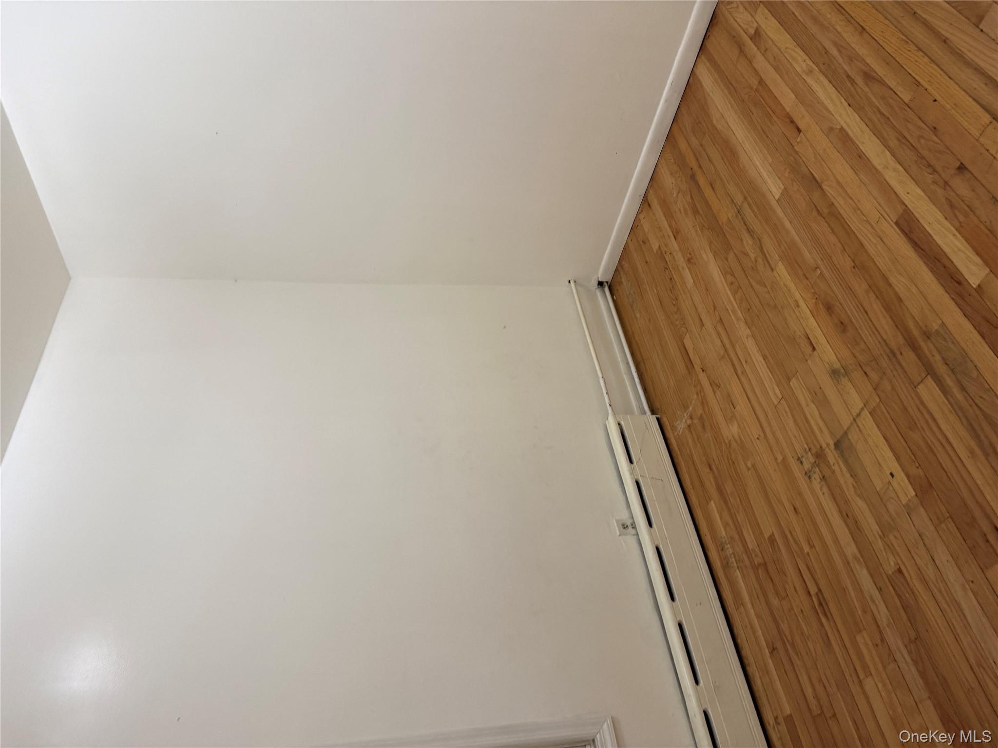 116-13 95th Avenue Queens, NY 11419 - Photo 5 of 7 a view of an empty room with wooden floor