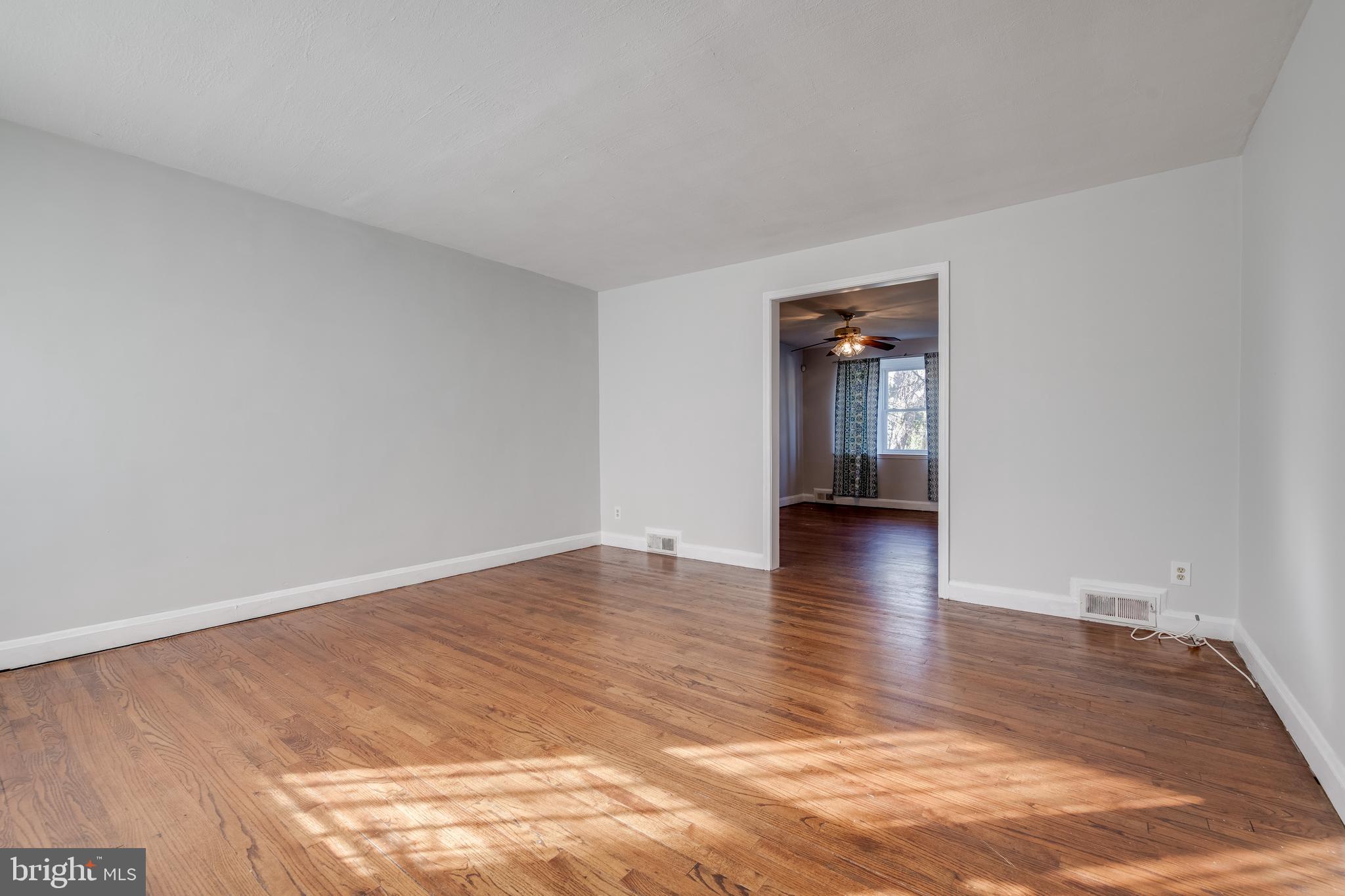 1306 East Cold Spring Lane Baltimore, MD 21239 - Photo 3 of 25 a view of a room with wooden floor and a window
