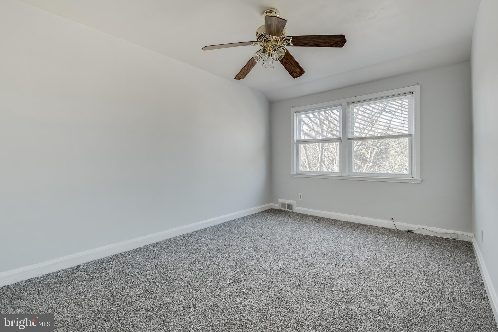 1306 East Cold Spring Lane Baltimore, MD 21239 - Photo 22 of 25 an empty room with ceiling fan and windows