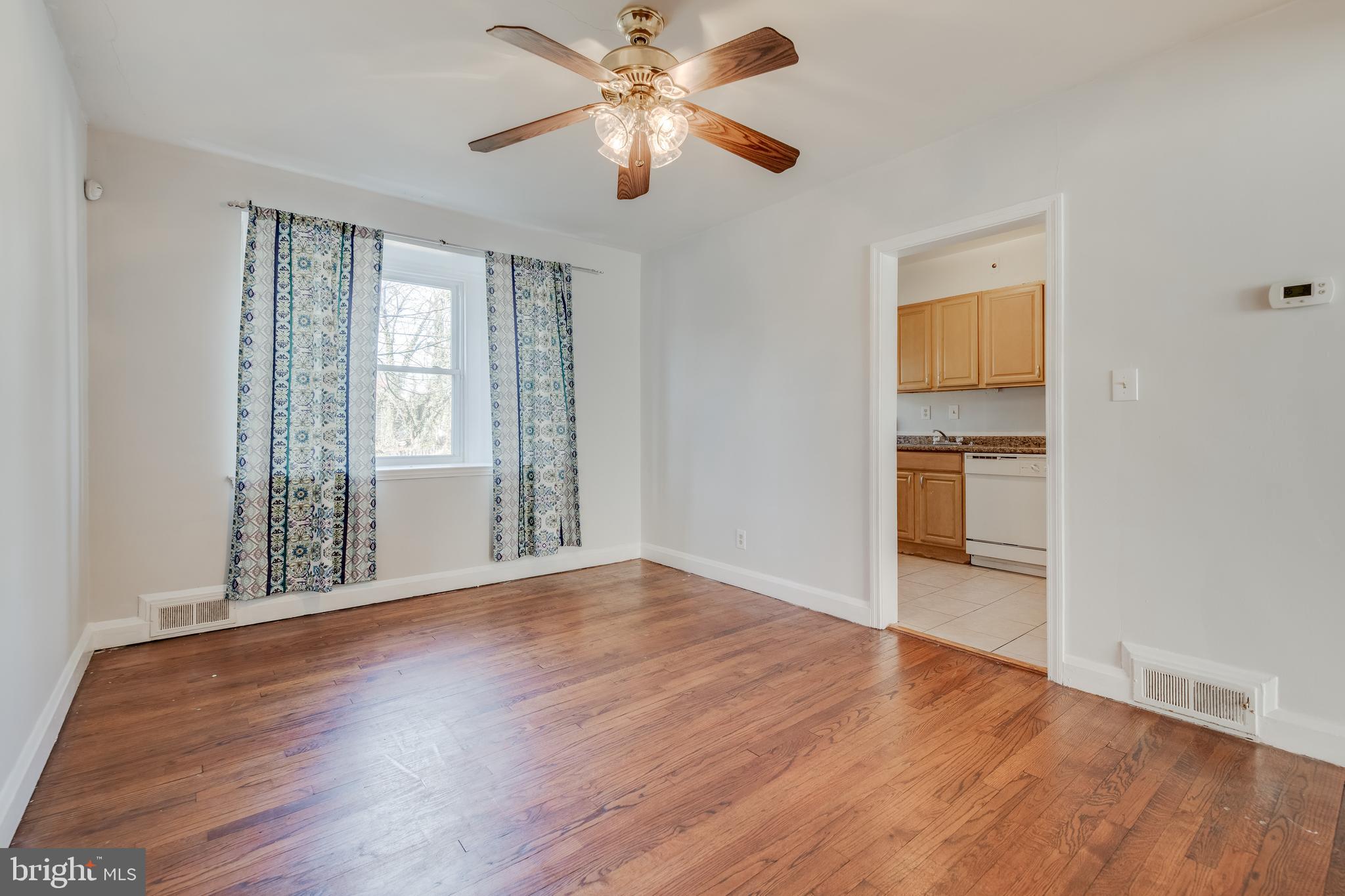 1306 East Cold Spring Lane Baltimore, MD 21239 - Photo 7 of 25 a view of empty room with wooden floor and fan