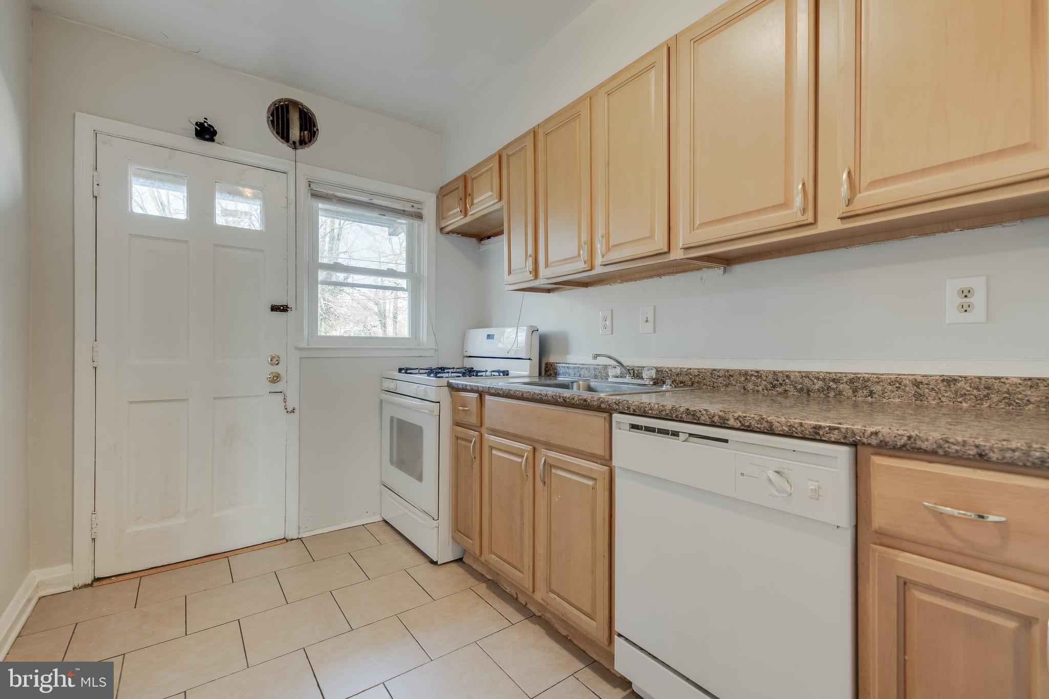1306 East Cold Spring Lane Baltimore, MD 21239 - Photo 9 of 25 a kitchen with granite countertop white cabinets and white appliances