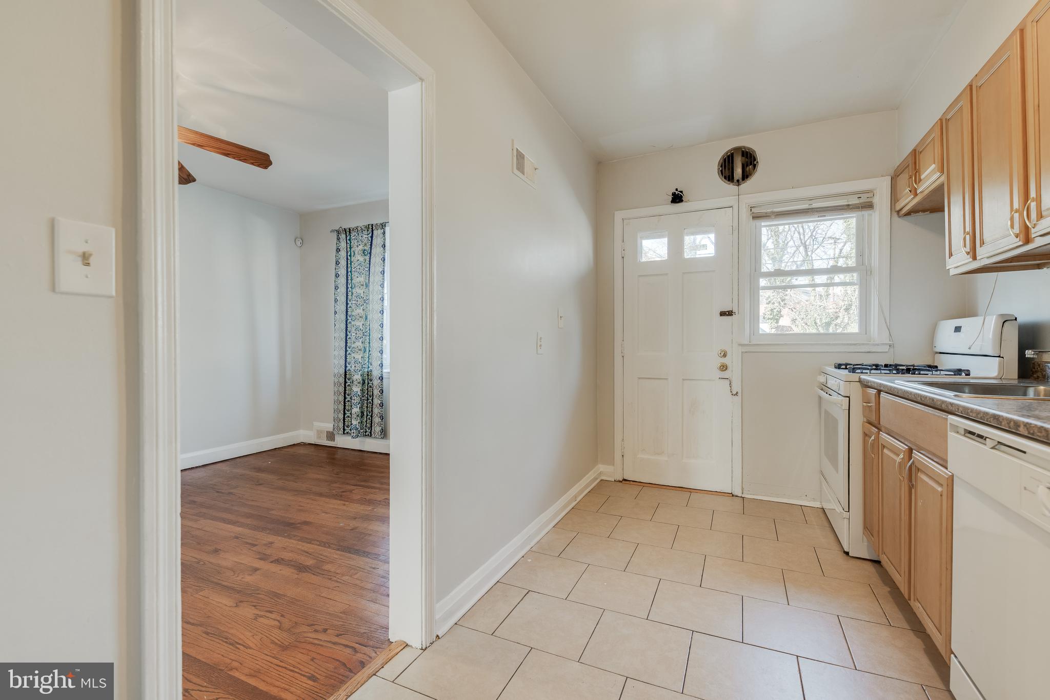 1306 East Cold Spring Lane Baltimore, MD 21239 - Photo 10 of 25 a view of a kitchen with a sink and dishwasher with wooden floor