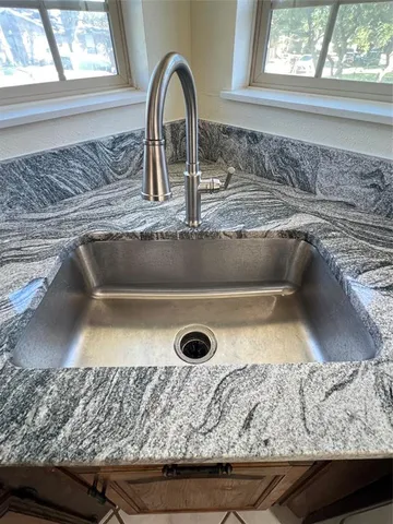 a kitchen with stainless steel appliances granite countertop a refrigerator a stove and a sink