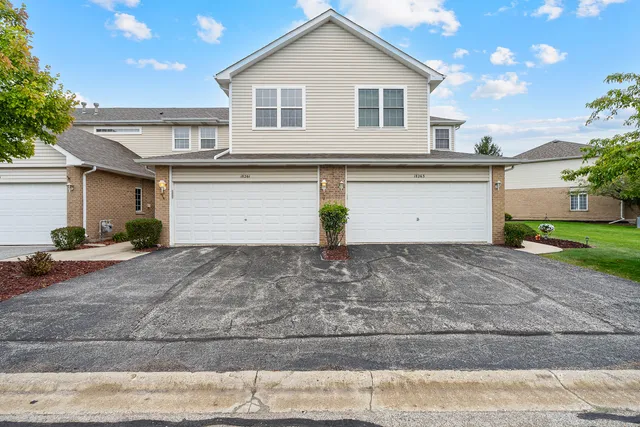 a view of a white house with a yard and a garage