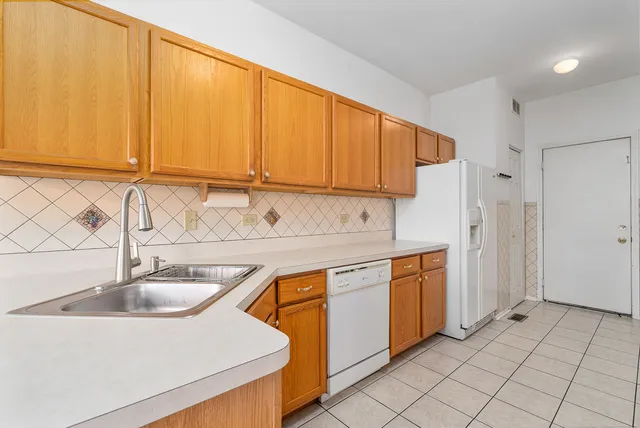 a kitchen with stainless steel appliances granite countertop a sink and a white cabinets