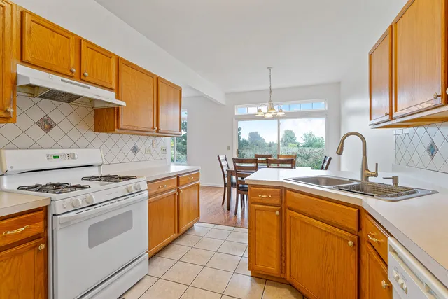 a kitchen with a stove sink and cabinets