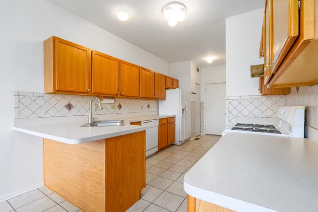 a kitchen with stainless steel appliances granite countertop a sink a stove and a refrigerator