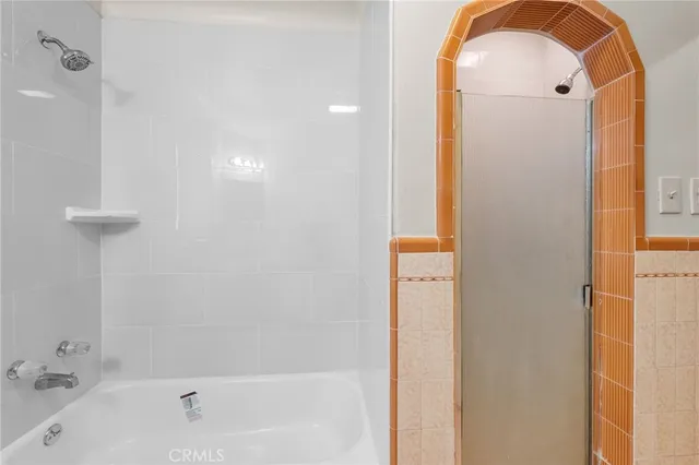 a bathroom with a tub shower and sink