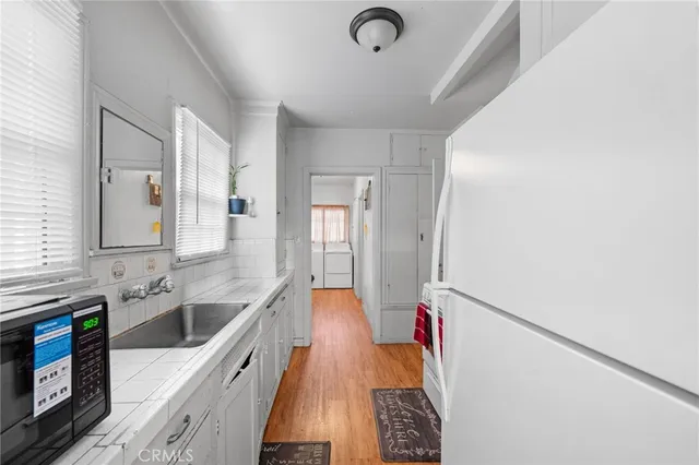 a view of a hallway with entryway and wooden floor