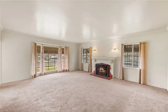 an empty room with fireplace and windows