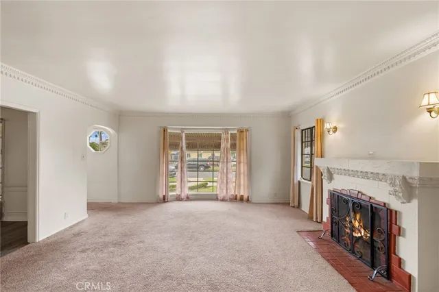 an empty room with windows and fireplace