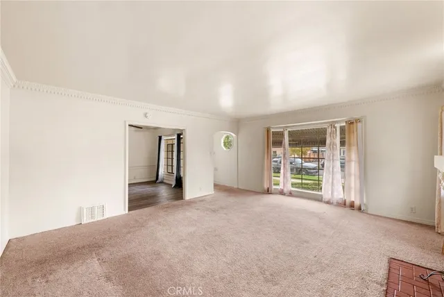 an empty room with windows and cabinet