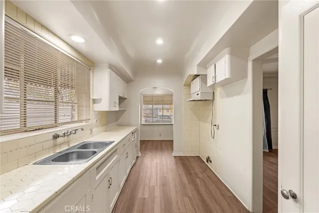 a view of a kitchen cabinets a sink and wooden floor