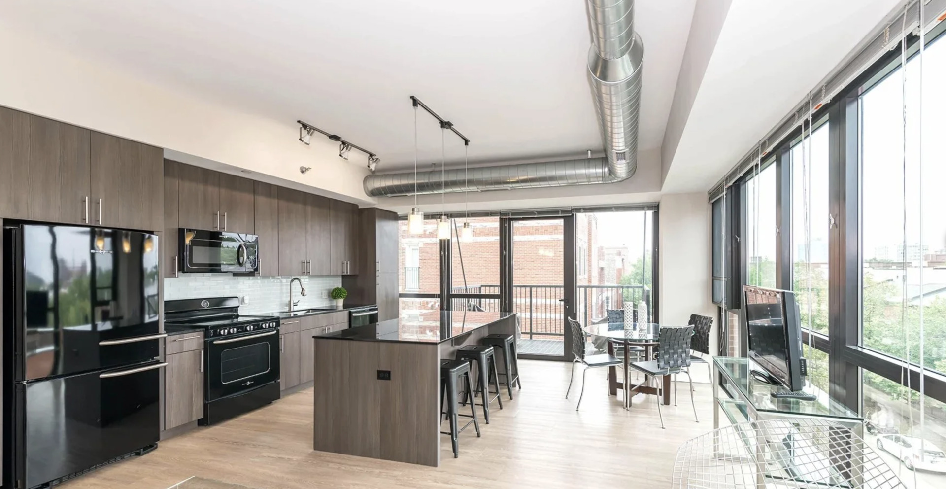 211 West Scott Street, Unit 408 Chicago, IL 60610 - Photo 3 of 8 a kitchen with stainless steel appliances granite countertop a stove refrigerator and a dining table with wooden floor