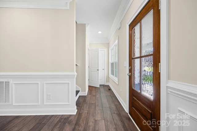 a view of a livingroom with wooden floor and a kitchen space