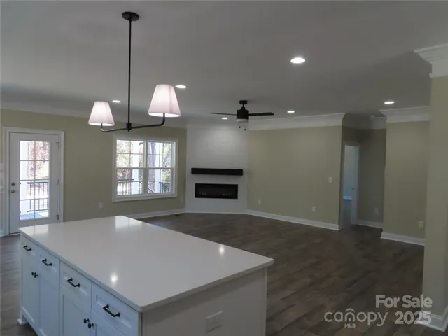 a view of a kitchen has a sink and dishwasher with wooden floor