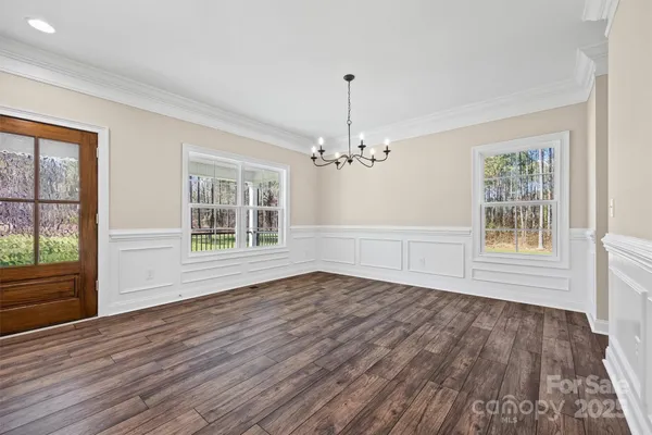 a large kitchen with cabinets wooden floor and stainless steel appliances