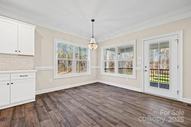 a view of a livingroom with a fireplace a ceiling fan and wooden floor