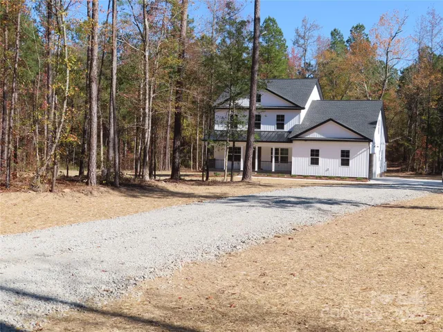 a front view of a house with a snow on the road