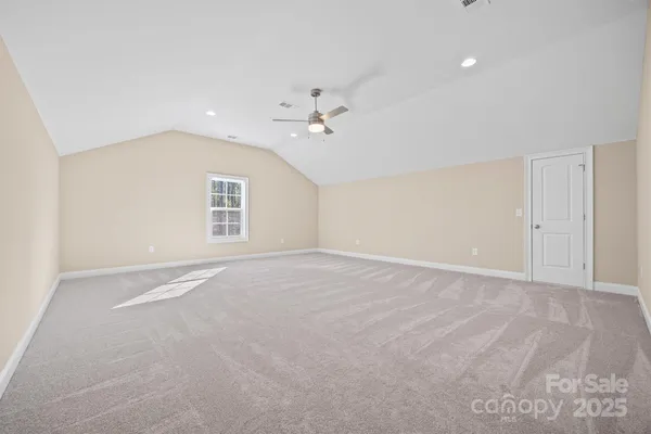 an empty room with a ceiling fan and a window