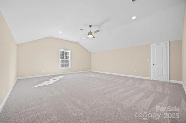 an empty room with a ceiling fan and a window