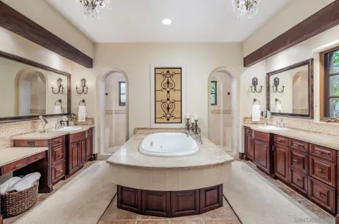 a bathroom with a granite countertop double vanity sink and a mirror