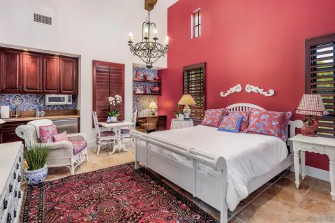 a bedroom with a bed a chandelier and dresser