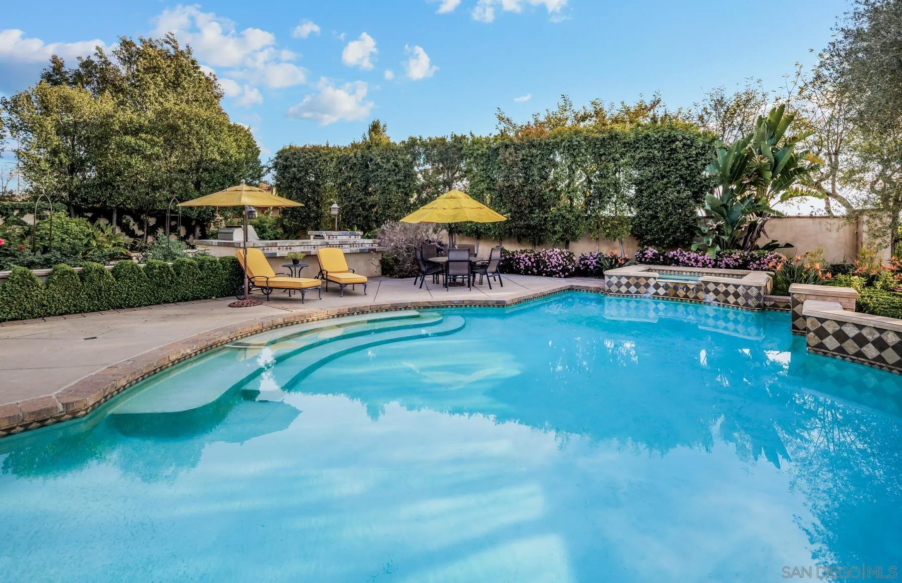 18669 Via Catania Rancho Santa Fe, CA 92091 - Photo 34 of 39 a view of a swimming pool with lawn chairs under an umbrella