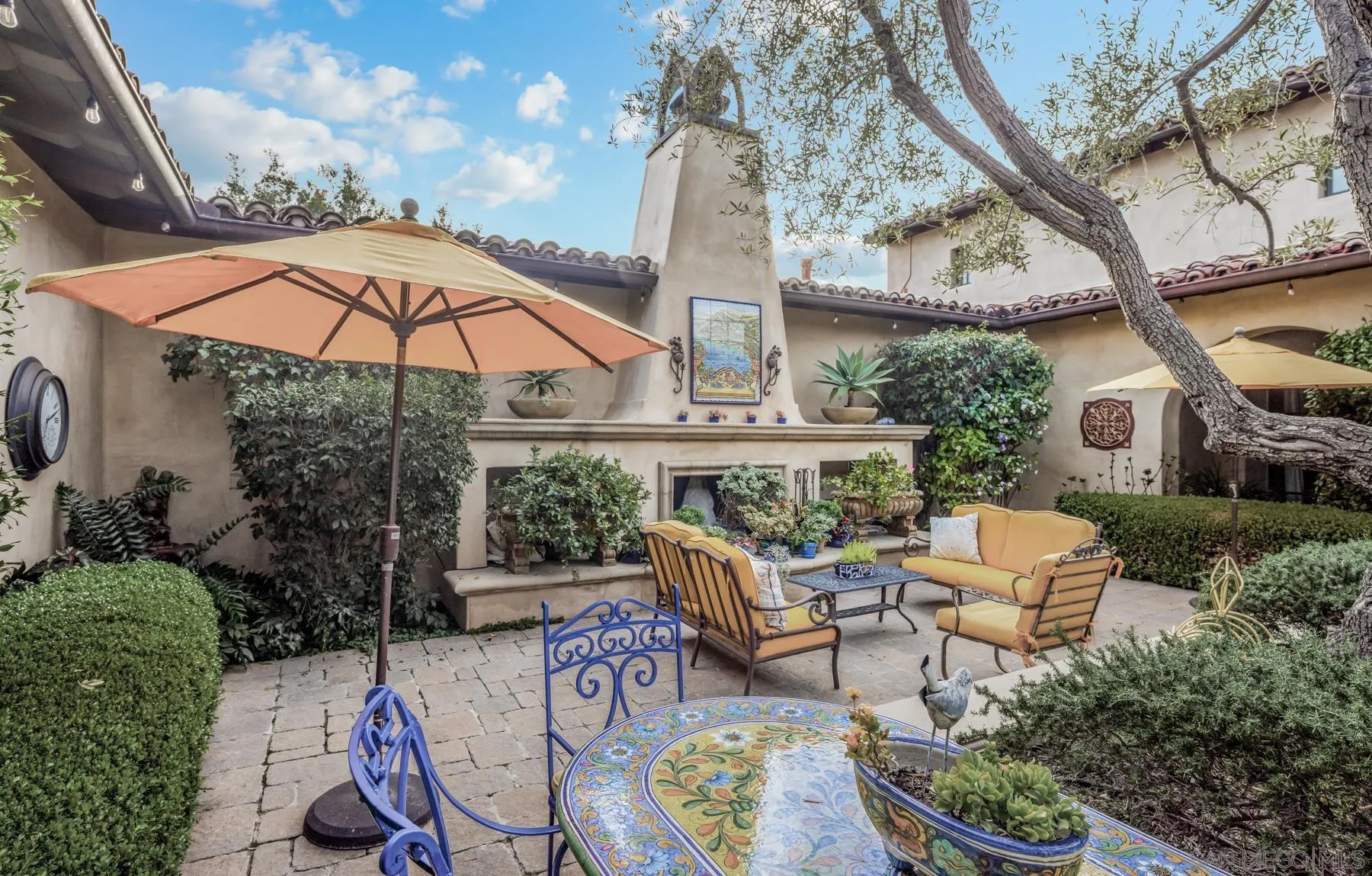 18669 Via Catania Rancho Santa Fe, CA 92091 - Photo 36 of 39 a view of a patio with couches table and chairs under an umbrella with a fire pit