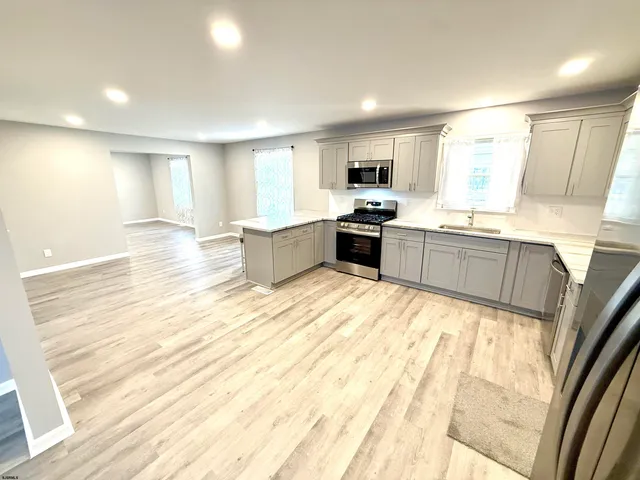 a large kitchen with kitchen island a sink wooden floor and counter top space