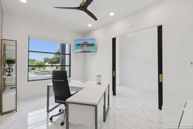 a room with stainless steel appliances kitchen island granite countertop a sink cabinets and wooden floor