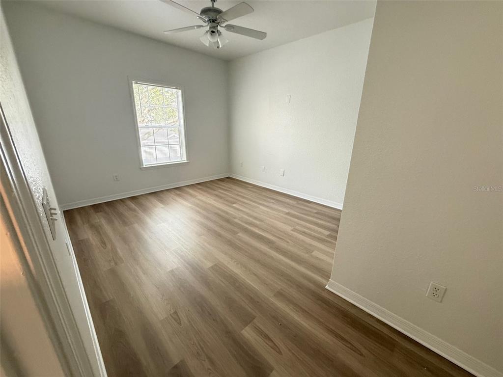 3611 Conroy Road, Unit 825 Orlando, FL 32839 - Photo 11 of 27 an empty room with wooden floor fan and windows