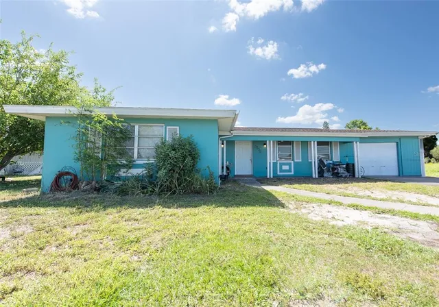 a view of a house with a yard and sitting area
