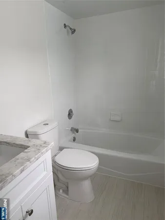 a bathroom with a granite countertop toilet a sink and bathtub