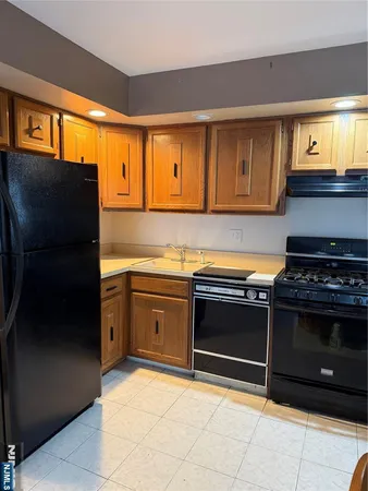 a kitchen with stainless steel appliances granite countertop a stove a refrigerator and a sink