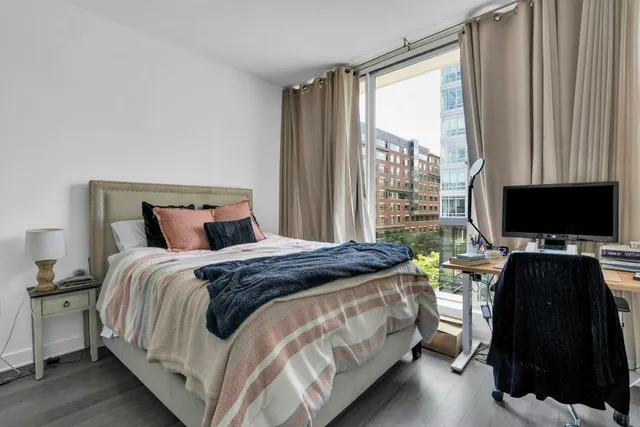 a bedroom with a bed and a flat tv screen on dresser