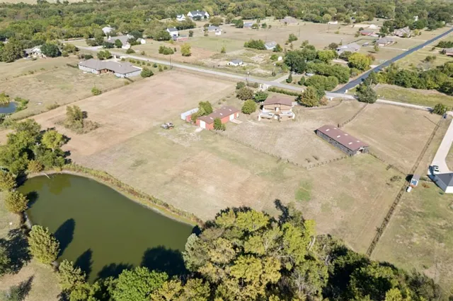 an aerial view of a house with a yard and lake view