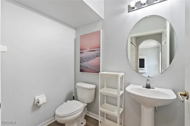 a bathroom with a toilet a sink and mirror