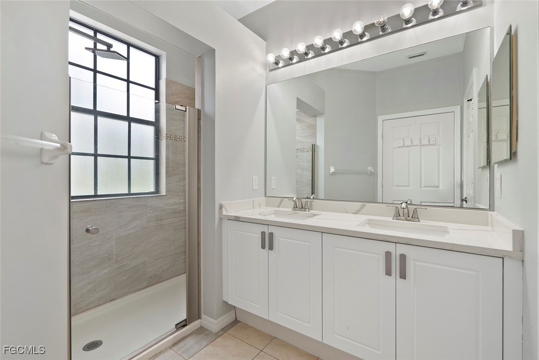 14617 Sutherland Avenue, Unit 80 Naples, FL 34119 - Photo 19 of 46 a bathroom with double sink and a mirror